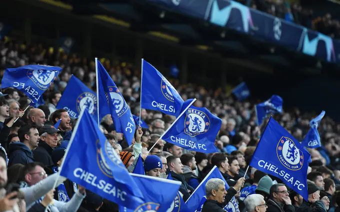 Chelsea fans wave flags at Stamford Bridge.