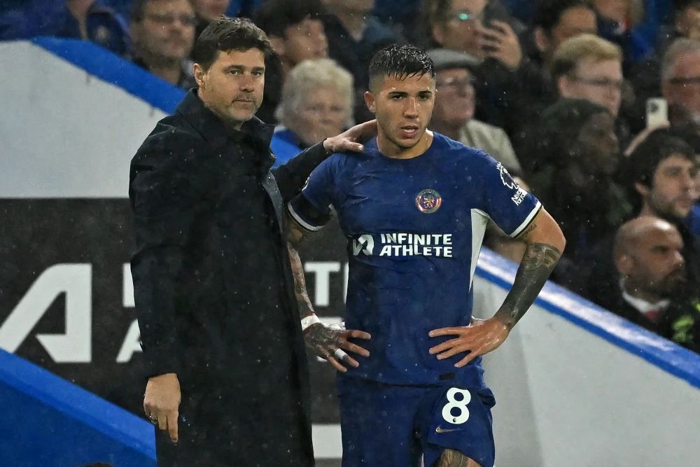 Mauricio Pochettino stands on the touchline with Enzo Fernandez.