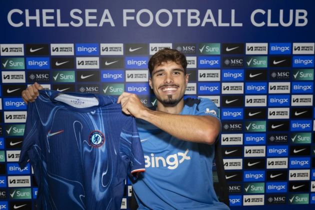 Pedro Neto holds up his Chelsea shirt after signing.