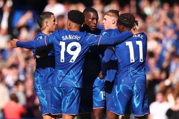 Chelsea players celebrate a goal in a huddle.