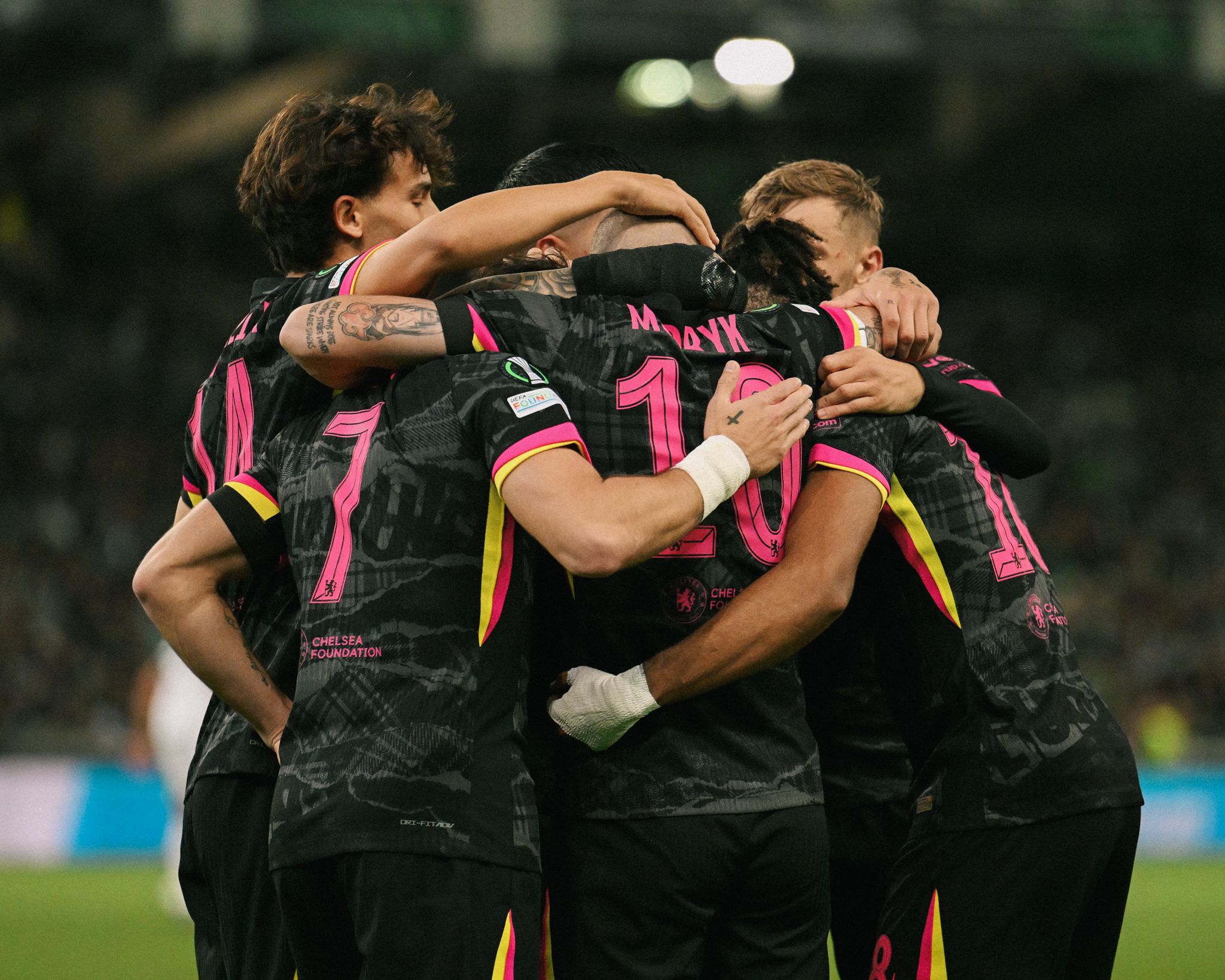 Chelsea team celebrate in a group huddle after Conference League game.