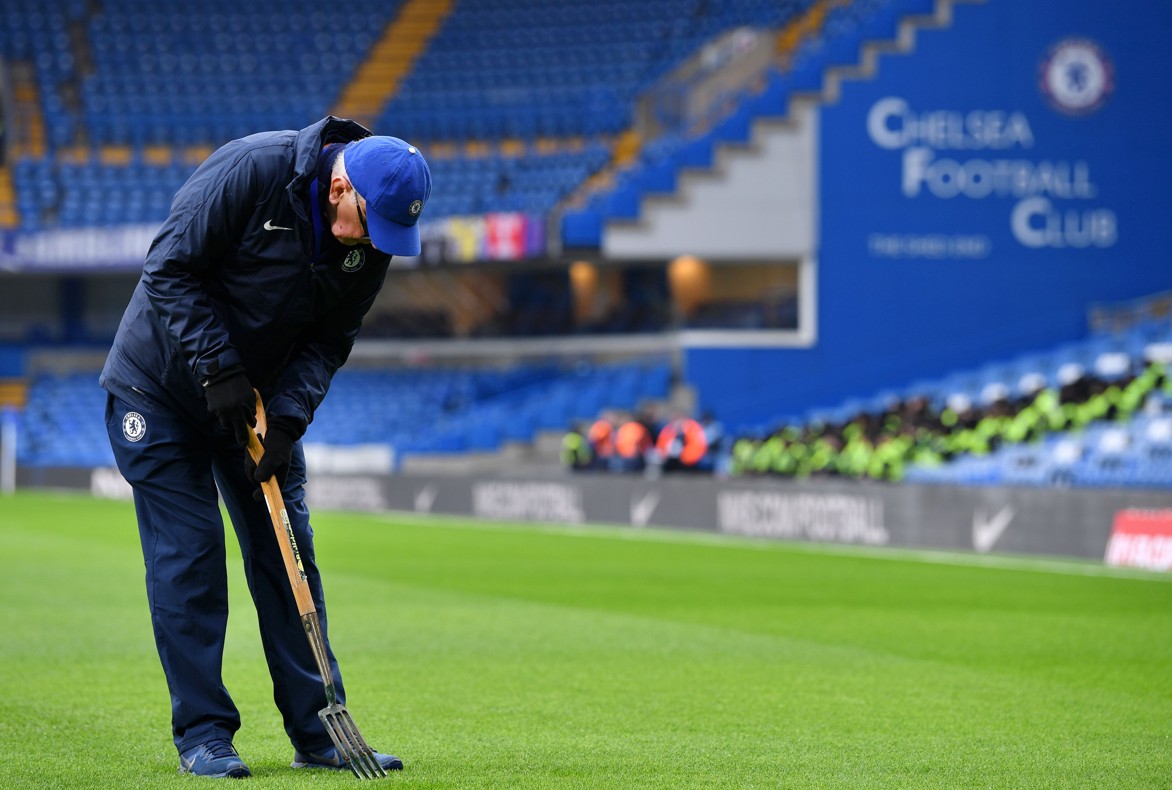 A groundsman works on the pitch at Stamford Bridge. (Photo by Justin Setterfield/Getty Images)