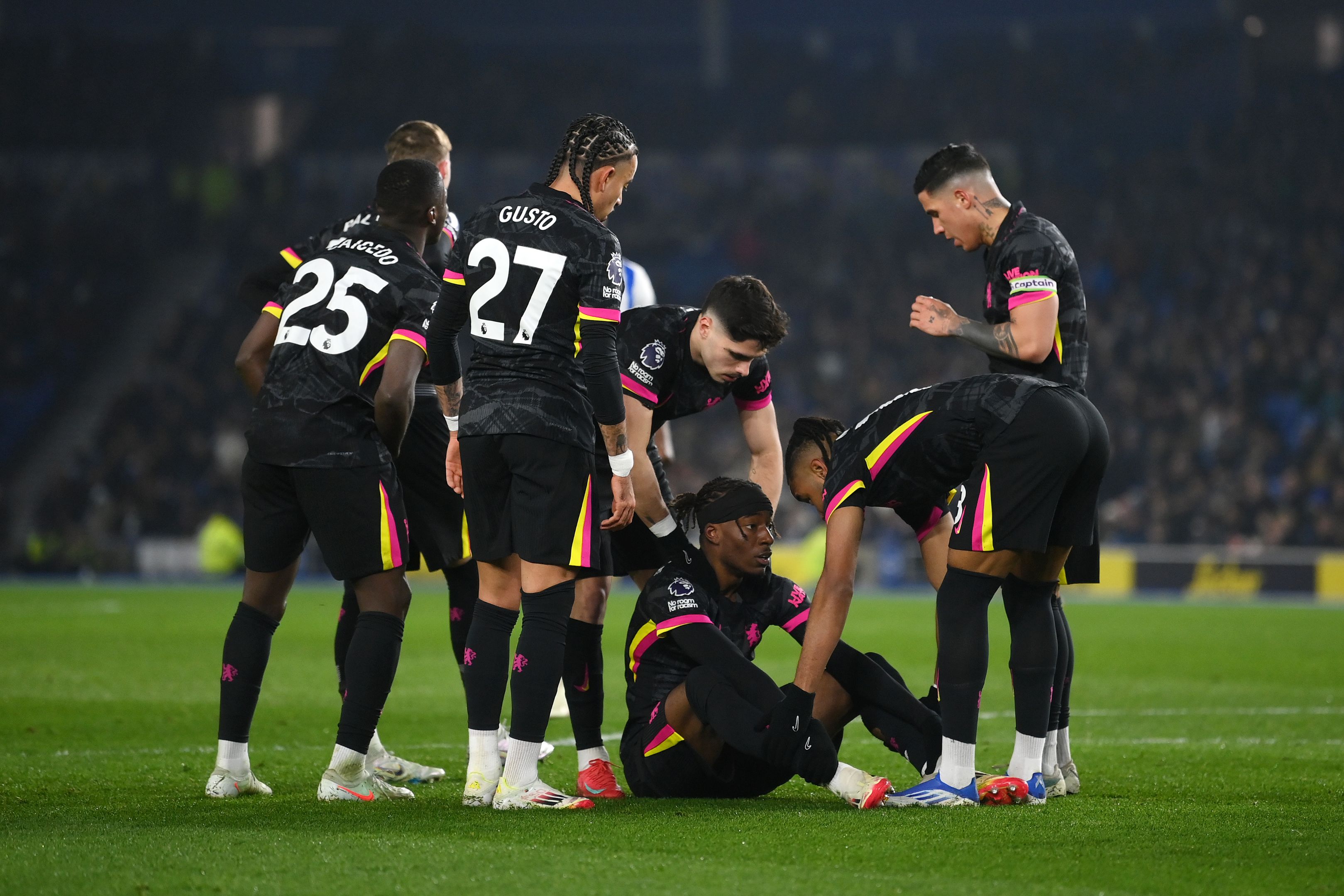 Chelsea gather around an injured Noni Madueke.