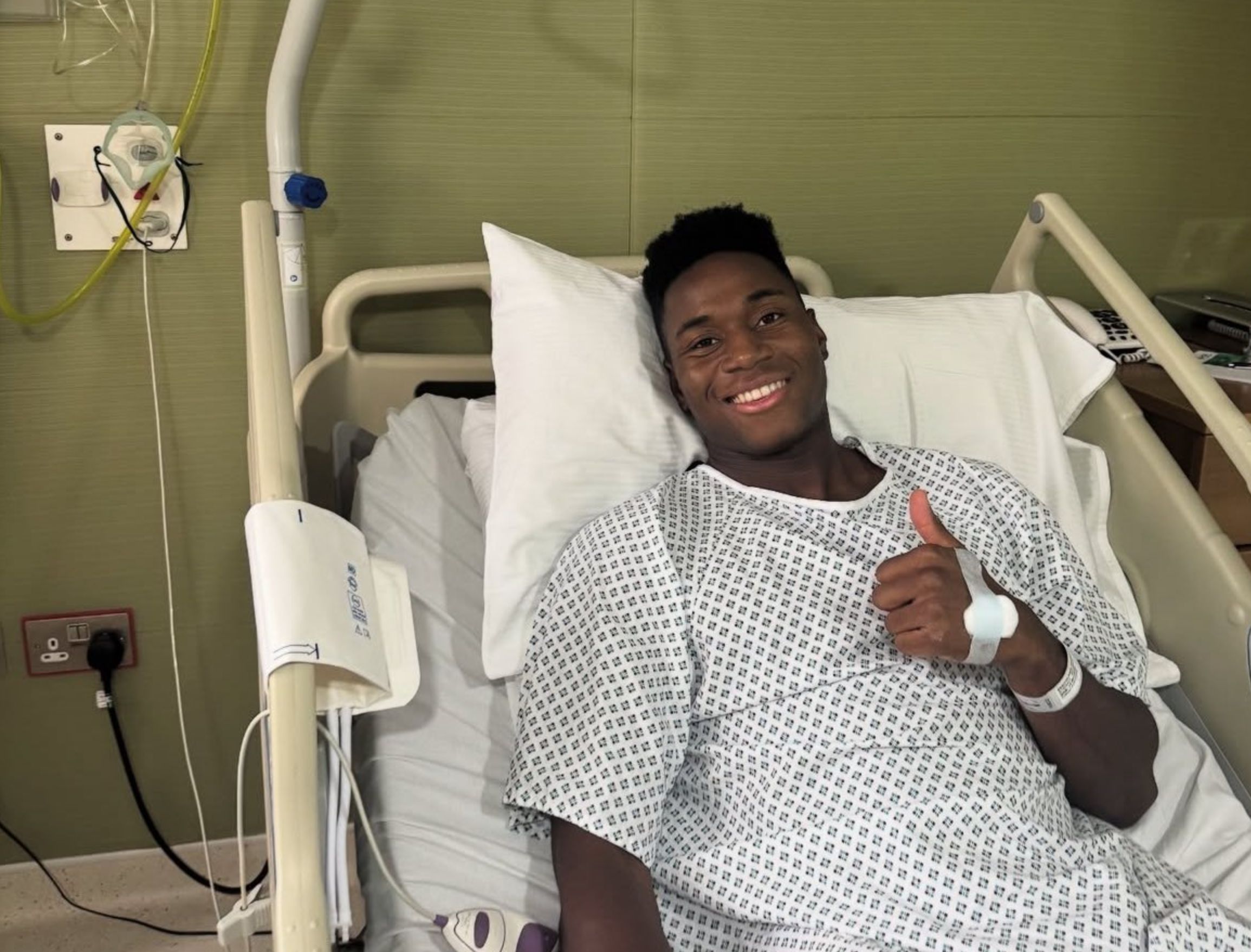 Dario Essugo in a hospital bed after surgery.